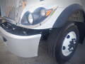 A 2016 International WorkStar 7500 truck with a chrome grille, a round headlight, and a white wheel with black bolts