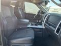 Interior view of a 2011 RAM 1500 showing two front seats with a console in between and dashboard controls visible