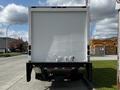 A rear view of a 2016 Isuzu NQR box truck with a white cargo area and a black chassis