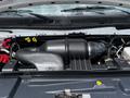 The engine compartment of a 2018 Ford Econoline showing the air intake system and various engine components with hoses and wiring visible