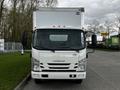 Front view of a white 2022 Isuzu NPR box truck with a flat cab and large cargo area on the back