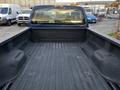 The image shows the empty bed of a blue 2008 Ford F-250 SD with a textured black liner and a tailgate in the closed position