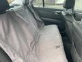 A 2007 Mercedes-Benz E-Class with a back seat covered by a grey protective cover featuring a hole in the fabric