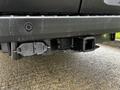 The rear hitch of a 2021 Ford Transit showing the hitch receiver and electrical connector for towing