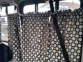 A 2012 Chevrolet Express van interior featuring patterned curtains covering windows and secured with seatbelts