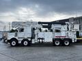 A white 2011 Western Star Trucks 4900 with an extended aerial lift and tool storage compartments on the side