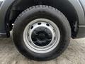 Close-up of a 2020 Ford Transit wheel featuring a black rim and a tire with prominent treads