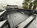 A 2022 GMC Sierra 3500HD truck bed featuring a textured black liner with rain droplets on the surface and a spacious interior designed for hauling and towing