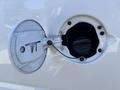 Close-up of the fuel cap of a 2019 GMC Savana with the cap partially open and a warning label visible inside the fuel filler neck