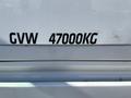 A close-up view of a white Freightliner Cascadia truck showcasing the label indicating a gross vehicle weight of 47000 kg