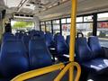 Interior view of a 2019 Chevrolet Express showing rows of blue upholstered seats and yellow handrails with no passengers seated