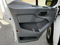 A grey door panel of a 2015 Ford Transit featuring a handle and storage compartment
