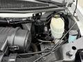 A close-up view of a 2013 Chevrolet Express engine compartment featuring components like the air intake filter oil filter and various fluid reservoirs