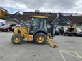 A yellow 2012 John Deere 310SJ backhoe loader with a front bucket and rear excavator arm parked in a lot