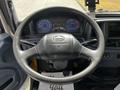 Steering wheel and dashboard of a 2006 Hino 268 displaying gauges and controls with a floor mat visible
