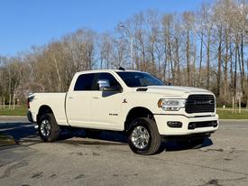 A 2023 RAM 3500 pickup truck in white with chrome accents parked on a street with a clear view of its front and side features