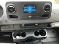 Dashboard of a 2023 Mercedes-Benz Sprinter featuring a touch screen display and a compartment with cup holders below