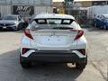A 2021 Toyota C-HR viewed from the rear with distinctive taillights a sleek design and absence of a license plate