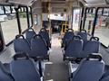Interior of a 2018 Chevrolet Express bus showing rows of blue fabric seats and the driver’s area at the front with a steering wheel and dashboard in view