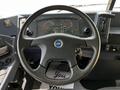 The image shows the interior of a 2022 Blue Bird BB Conventional bus featuring a black steering wheel a dashboard with gauges and control buttons
