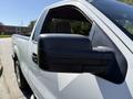 A 2014 Ford F-150 with a black side mirror visible from the passenger side angle