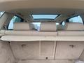 Interior view of a 2009 BMW X5 showing the rear seats and cargo area with beige upholstery and a retractable cover