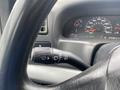 Close-up of the turn signal lever and dashboard of a 2003 Ford F-450 SD showing speedometer and warning lights