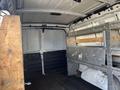 A 2016 GMC Savana interior showing an empty cargo area with metal shelving and wooden supports along the sides