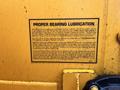 A yellow warning label detailing proper bearing lubrication for a 1993 Bandit 200+ wood chipper emphasizing the importance of maintenance and contamination prevention