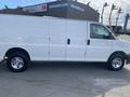 A 2022 GMC Savana van in white with a high roof and side sliding doors parked on a lot with chrome wheels and no visible branding