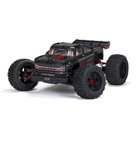 A black Arrma 1/5 Outcast 8S EXB AVC 4X4 RTR brushless stunt truck with large tires and a sleek body design featuring red accents and aggressive styling