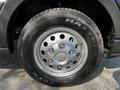Close-up of a silver wheel from a 2021 Ford Transit featuring a five-bolt pattern and a Maxxis tire with prominent tread design