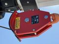 A red pulley with a safety warning label and a metal hook attached to it mounted on machinery