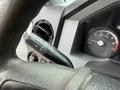A Ford F-350 SD steering wheel with dashboard controls and gauges visible including a speedometer and a lever for lights or wipers
