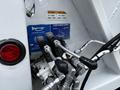 A close-up of the control panel for a 2014 Hino 195 featuring hydraulic levers and buttons labeled for driver alert and container dump操作