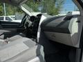 Interior of a 2009 Dodge Grand Caravan featuring a steering wheel dash and fabric seats with a gray color scheme and multiple controls on the dashboard