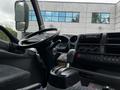 Interior of a 2014 Hino 195 truck featuring a steering wheel gear shift and control panel with various buttons and displays