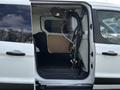 A 2016 Ford Transit Connect with an open rear door showing the interior and exposed wiring and equipment mounted inside