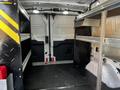 Interior of a 2018 Ford Transit cargo van showing shelving units and a spacious open area for storage