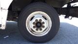 Close-up of a 2011 Ford Econoline wheel showcasing the tire and white steel rim with multiple lug nut holes