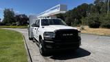 A 2019 RAM 3500 truck with a service body and ladder rack parked on a driveway