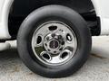 Close-up of a chrome wheel with a GMC logo mounted on a large black tire of a 2023 GMC Savana