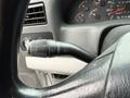Close-up of the turn signal lever on a steering column of a 2000 Ford F-450 displaying controls for headlights and wipers