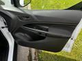 A black door panel of a 2016 Ford Transit Connect featuring a handle and control buttons