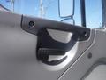 Close-up of a door handle on a 2005 Freightliner M2 106 Medium Duty truck interior showing a textured grip and surrounding panel details