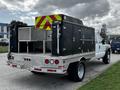 A 2007 Ford F-550 is equipped with a service body featuring storage compartments and a reflective safety design on the back
