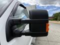 Close-up of the side mirror of a white 2015 Ford F-350 Super Duty featuring a bold design and integrated amber marker light
