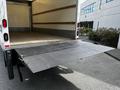 A 2018 Hino 195 truck with a lowered metal liftgate extending from the rear of the cargo area