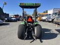 A 2008 John Deere 3320 300X tractor viewed from the rear showing large rear tires and a green and black body with a safety beacon on top