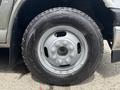 Close-up of a silver wheel and tire of a 2020 Chevrolet Express featuring a five-bolt pattern and Goodyear Wrangler tire tread design